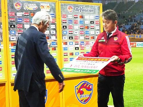 佐藤社長から「育成資金」が、ベガルタ仙台の菊池秀赦社長に贈呈された