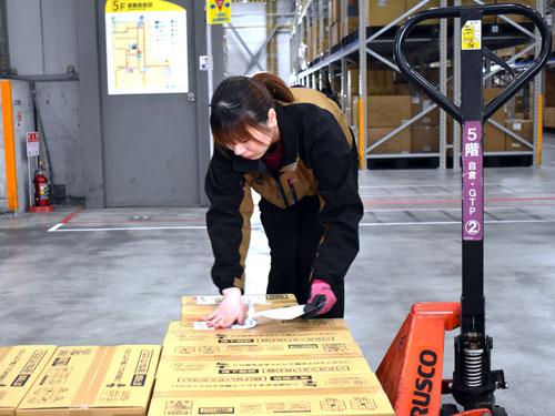 手作業で荷札を貼付