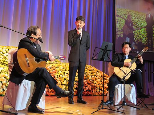 故人と親交の深かったギタリストの演奏も行われた（中央は山口社長）