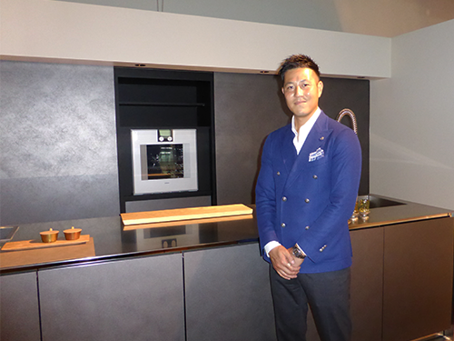 キッチンの前に立つ山根太郎社長