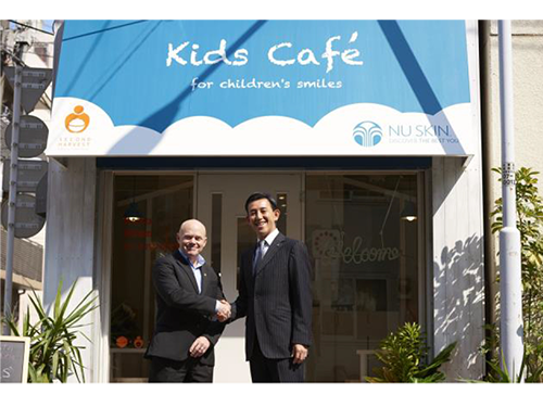 カフェ前で握手を交わすマクジルトン・チャールズ理事長と小林和則社長（写真右）