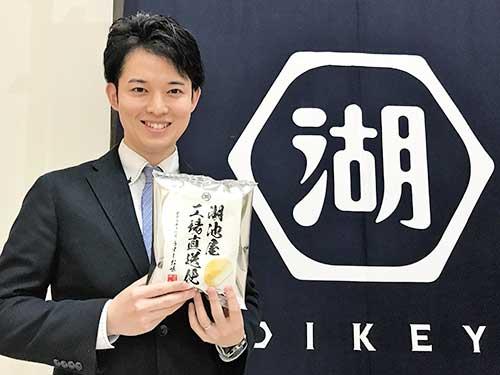 スナックEC課の佐藤剛一氏。持っているのは「湖池屋工場直送便」