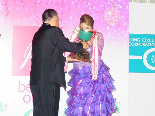 年間功労賞の小林美恵子さんを三橋社長が表彰