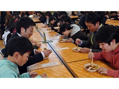 児童と試食をする、にしき食品・菊池洋一社長（写真左）と、岩沼市・佐藤淳一市長