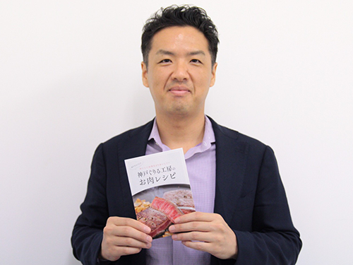 独自の肉料理のレシピブックを手にする井上直哉社長